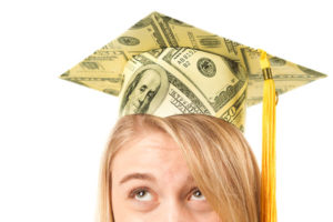 Graduate with a cap covered by dollar bills indicating student debt.