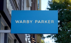 CHICAGO, ILLINOIS - SEPTEMBER 29: A sign marks the location of a Warby Parker store on September 29, 2021 in Chicago, Illinois. Warby Parker stock made its public debut today at $54.05-per-share, well above its $40 reference point. (Photo by Scott Olson/Getty Images)